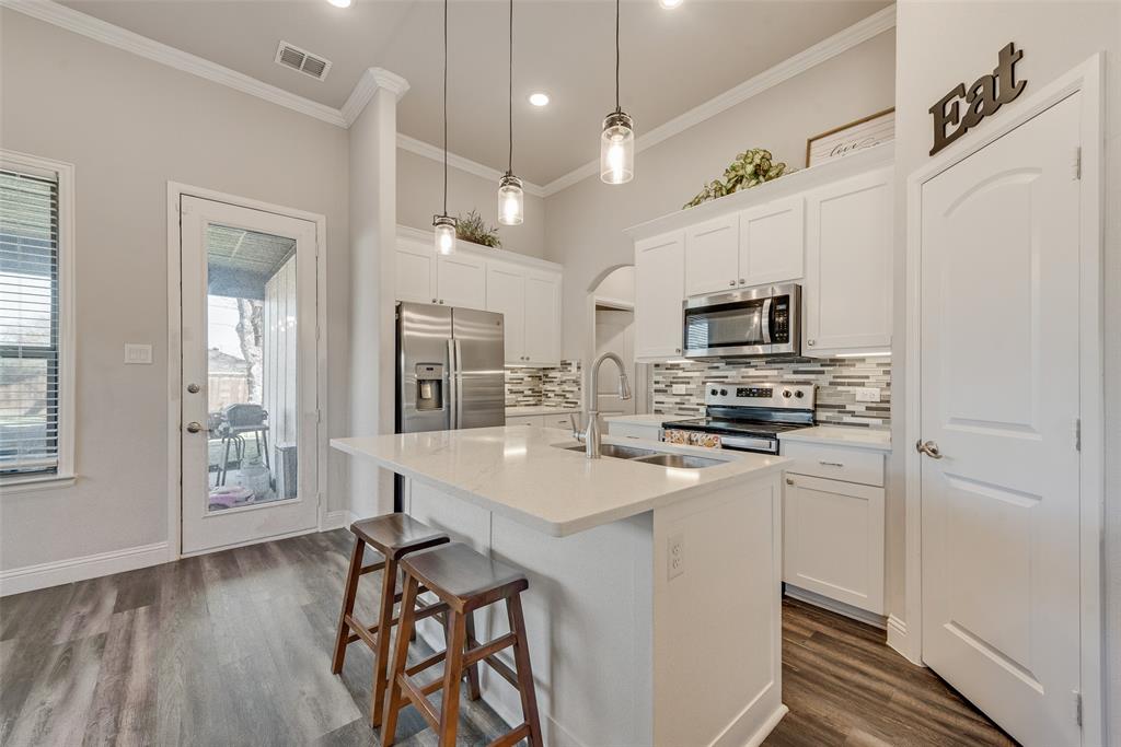 404 West Rochester Street Terrell, TX 75160 - Photo 5 of 24 a kitchen with stainless steel appliances a microwave a stove a sink dishwasher a refrigerator white cabinets with wooden floor