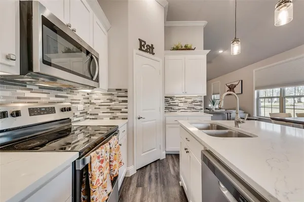 a kitchen with stainless steel appliances a sink stove and cabinets