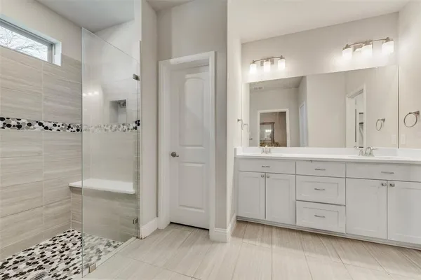 a spacious bathroom with a granite countertop sink a mirror and a shower