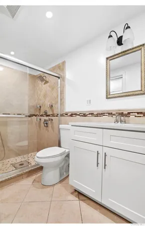 a bathroom with a granite countertop toilet and a sink