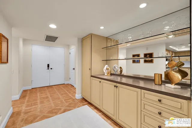 a kitchen with stainless steel appliances granite countertop a stove top oven a dining table and chairs with wooden floor