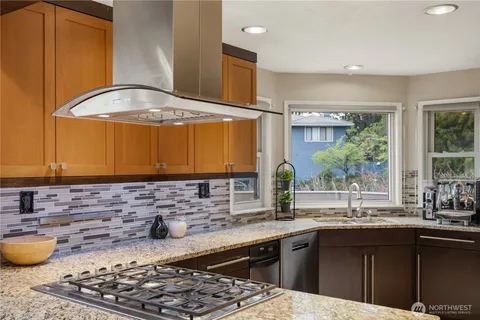 a kitchen with stainless steel appliances kitchen island granite countertop a sink stove and cabinets