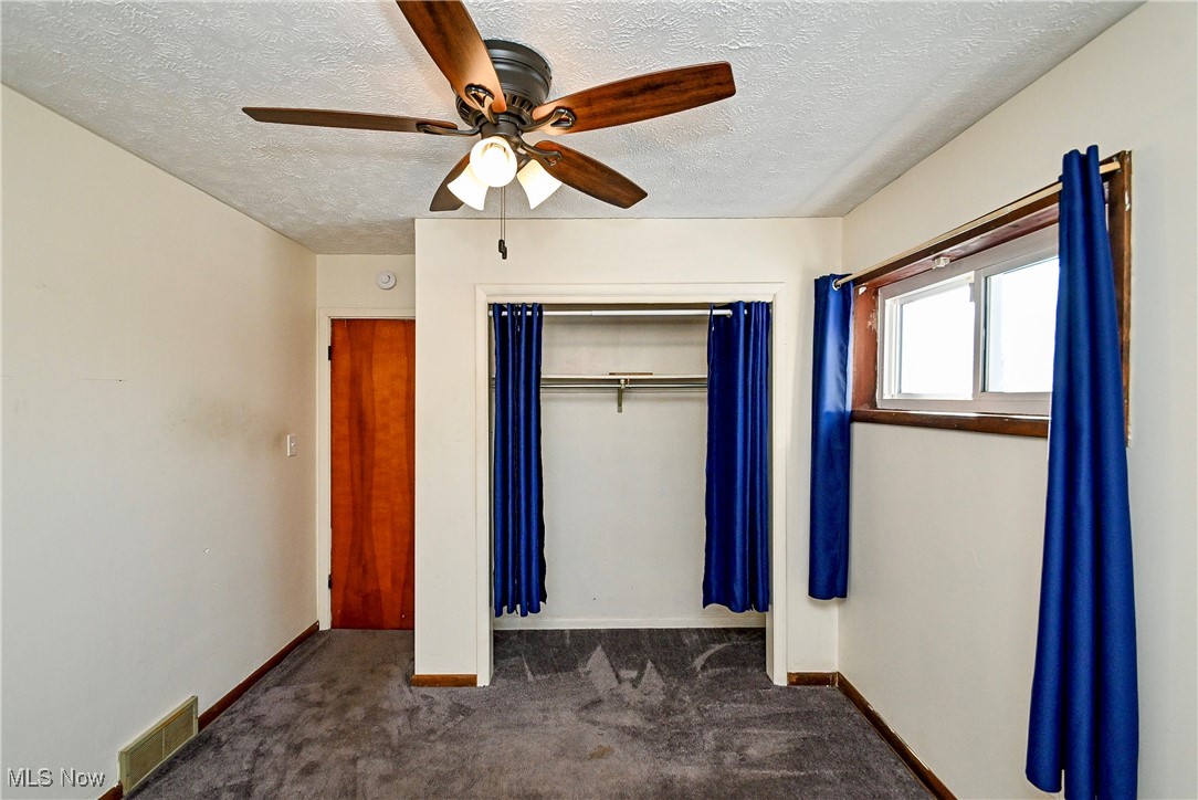 630 Neal Road Akron, OH 44312 - Photo 13 of 15 Bedroom with a closet, ceiling fan, a textured ceiling, and dark colored carpet