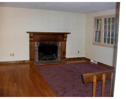 687 Townsend Road Groton, MA 01450 - Photo 6 of 17 a view of an empty room with wooden floor and a fireplace