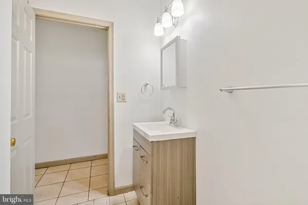 a bathroom with a sink a light fixture and a mirror