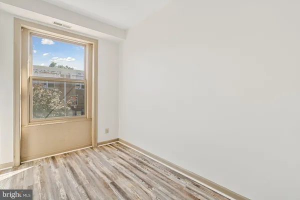 an empty room with wooden floor and a window