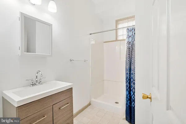 a bathroom with a sink mirror and shower