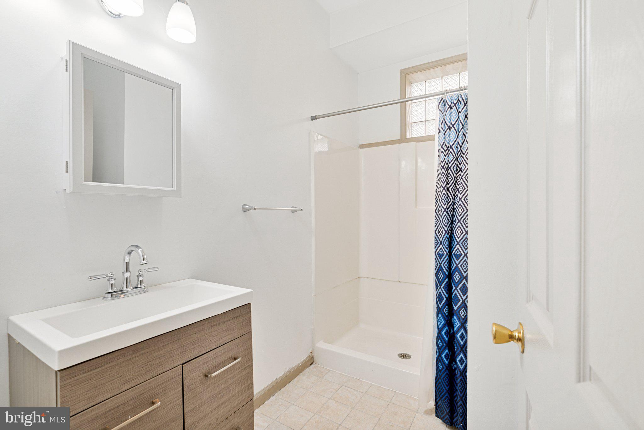 1621 West Diamond Street Philadelphia, PA 19121 - Photo 17 of 18 a bathroom with a sink mirror and shower