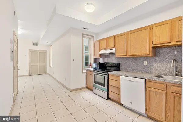 a kitchen with granite countertop white cabinets and stainless steel appliances
