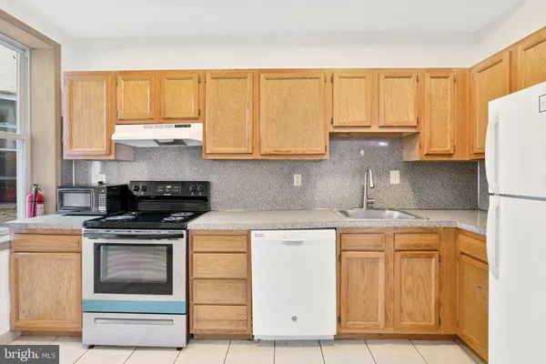 a kitchen with cabinets appliances and a counter space