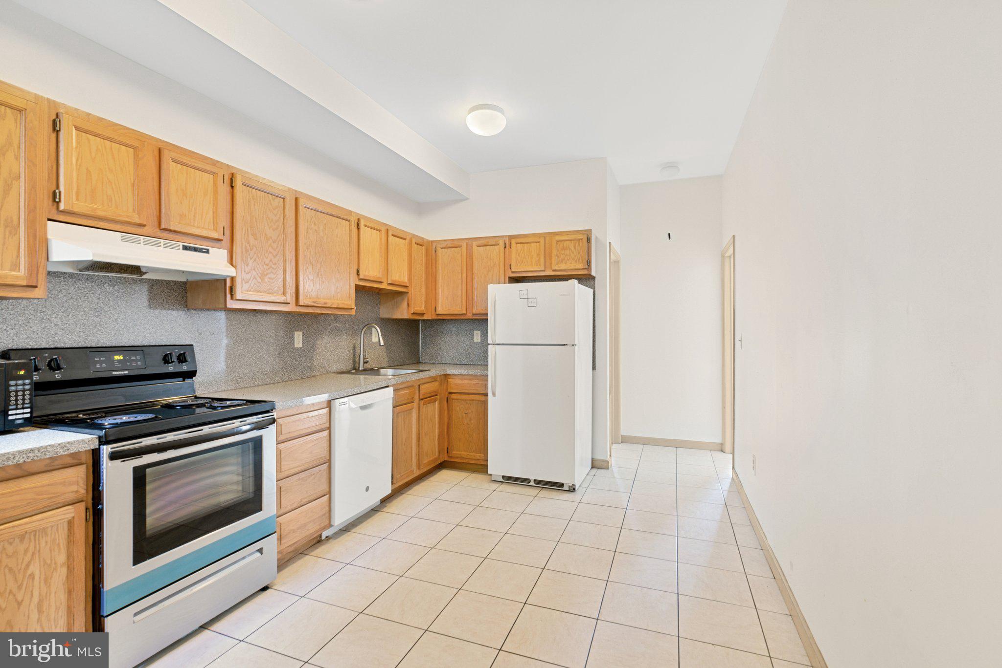 1621 West Diamond Street Philadelphia, PA 19121 - Photo 7 of 18 a kitchen with a stove a refrigerator and cabinets
