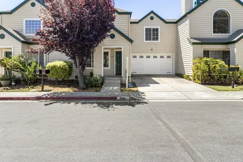 a front view of a house with yard and parking