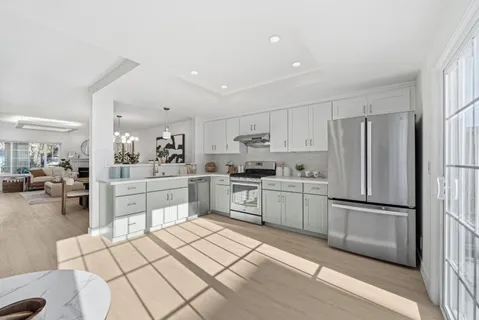 a kitchen with white cabinets and stainless steel appliances