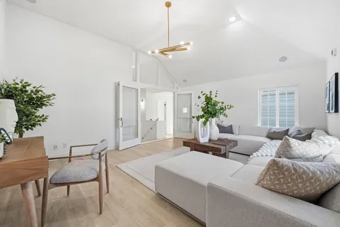 a living room with furniture potted plant and a chandelier