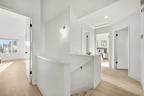 a view of a bedroom with wooden floor and windows