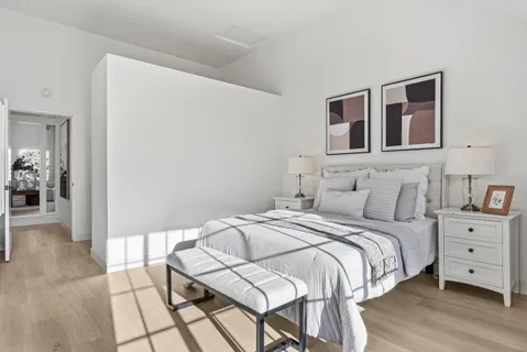 a spacious bedroom with a bed and wooden floor