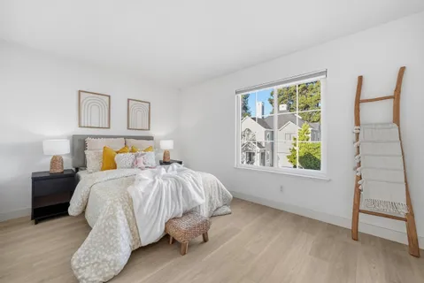 a bedroom with a bed and closet with wooden floor