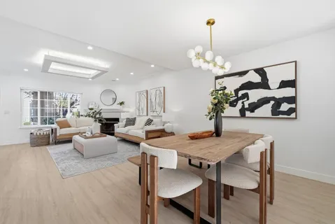 a view of a dining room with furniture a chandelier and wooden floor