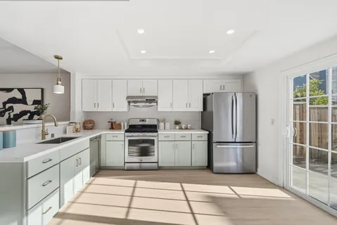 a kitchen with white cabinets and stainless steel appliances