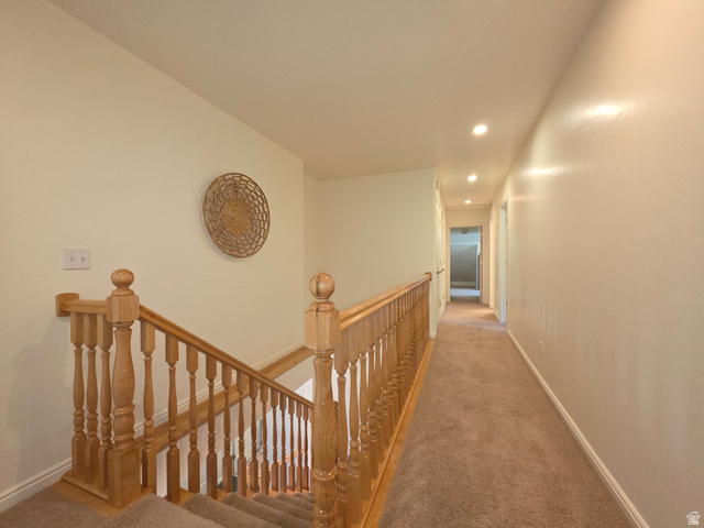 387 North Loafer Canyon Road Payson, UT 84651 - Photo 40 of 94 Carpeted staircase with natural wood balusters and handrail, leading to an upper-level hallway with recessed lighting and neutral wall tones