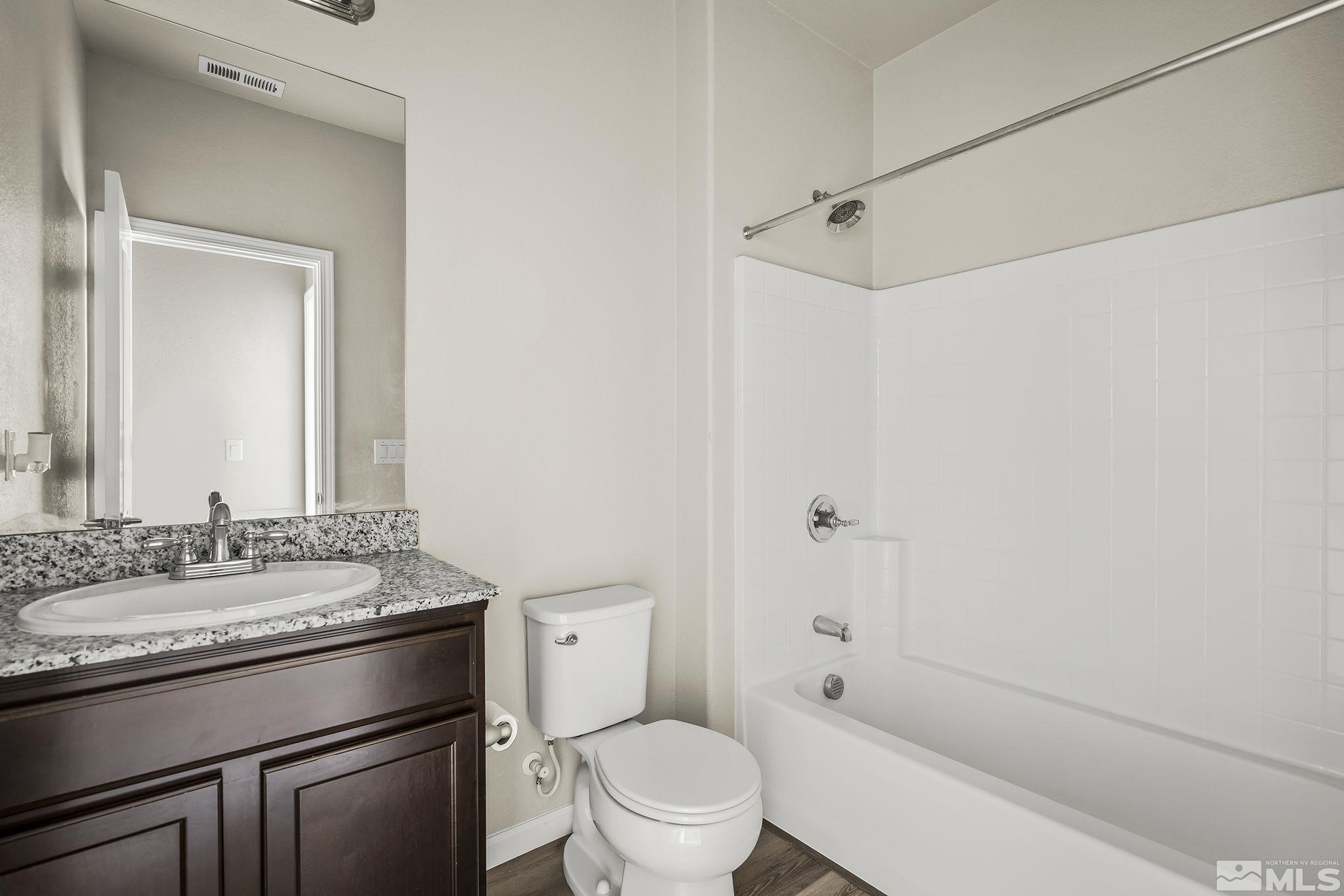 14420 Leiden Drive Reno, NV 89506 - Photo 13 of 16 a bathroom with a granite countertop sink toilet and shower