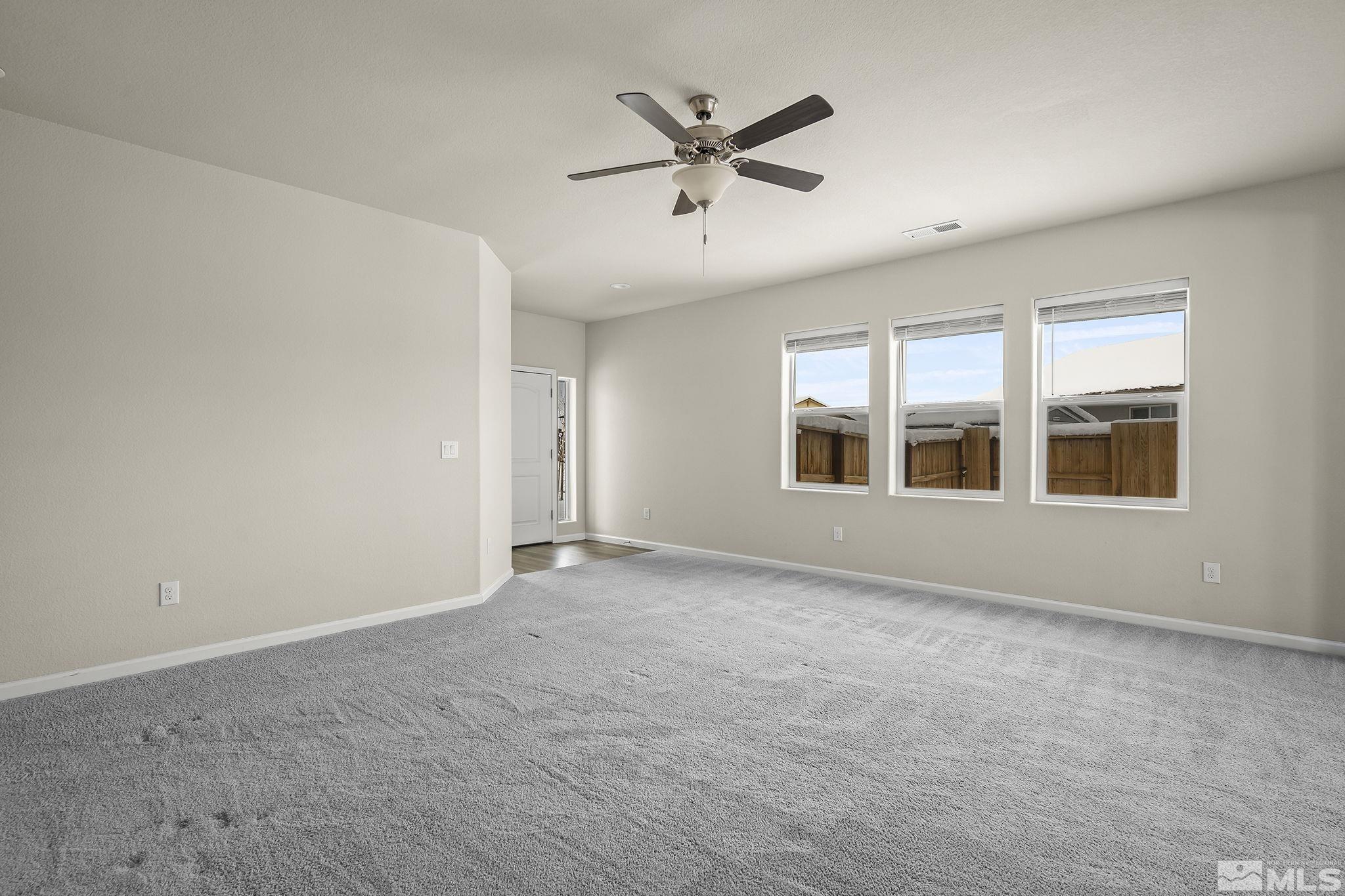 14420 Leiden Drive Reno, NV 89506 - Photo 4 of 16 an empty room with ceiling fan and windows