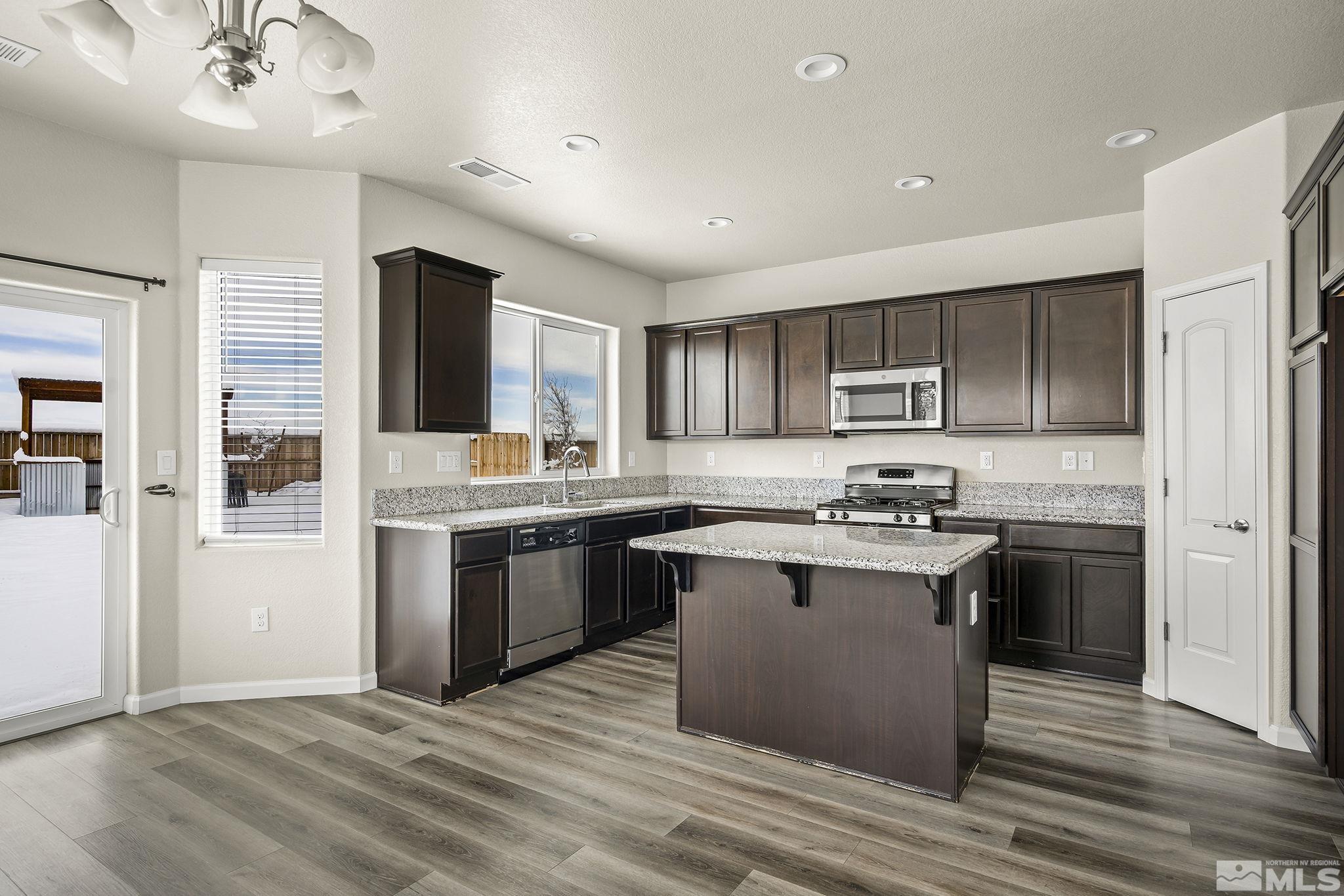 14420 Leiden Drive Reno, NV 89506 - Photo 7 of 16 a kitchen with stainless steel appliances granite countertop a stove top oven a sink dishwasher and a refrigerator