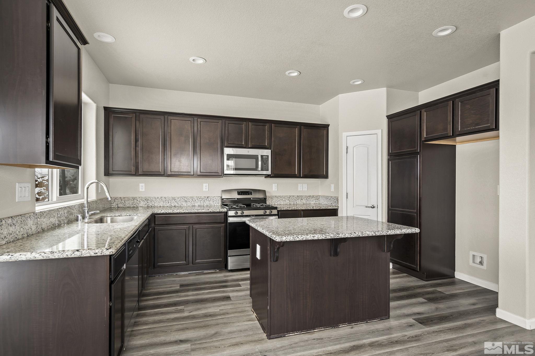 14420 Leiden Drive Reno, NV 89506 - Photo 8 of 16 a kitchen with stainless steel appliances granite countertop a sink stove and refrigerator