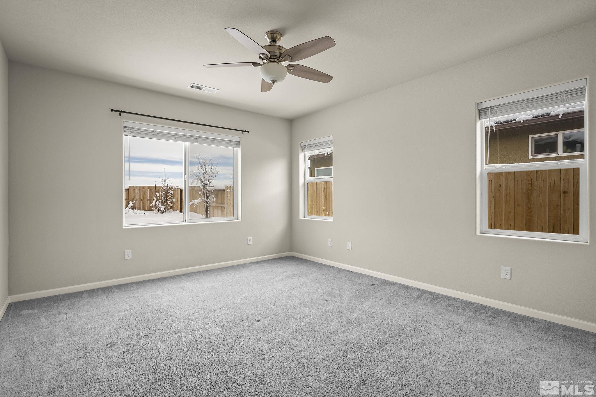14420 Leiden Drive Reno, NV 89506 - Photo 9 of 16 an empty room with windows and ceiling fan
