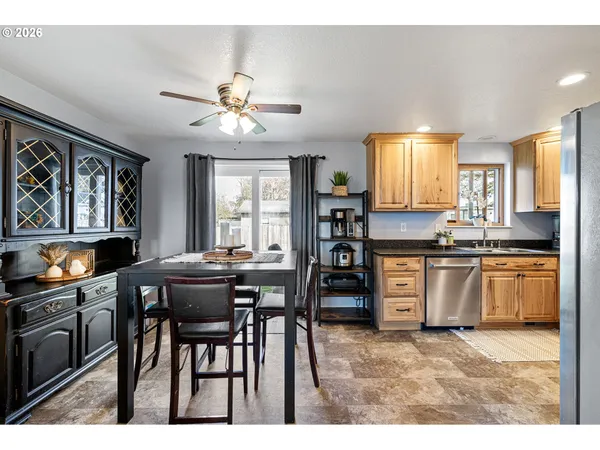 a kitchen with stainless steel appliances kitchen island granite countertop a stove a sink cabinets and a refrigerator