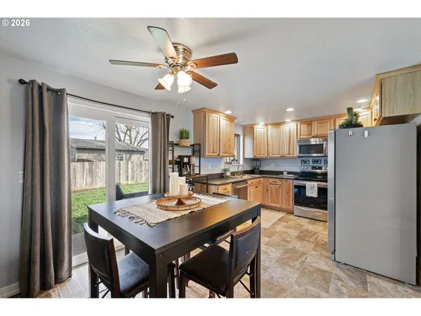 a open kitchen with a table chairs and refrigerator