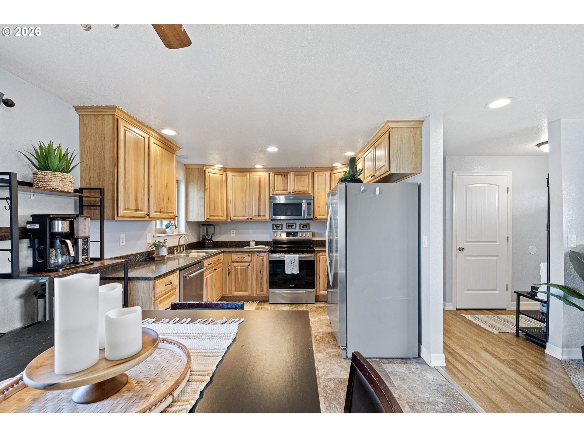 86 East 2nd Street Halsey, OR 97348 - Photo 16 of 36 a kitchen with stainless steel appliances kitchen island granite countertop a refrigerator a stove a sink dishwasher and white cabinets with wooden floor
