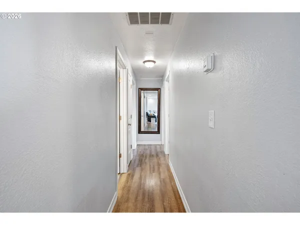 a view of a hallway with wooden floor