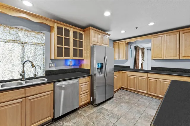 a kitchen with stainless steel appliances granite countertop a stove a sink and a refrigerator