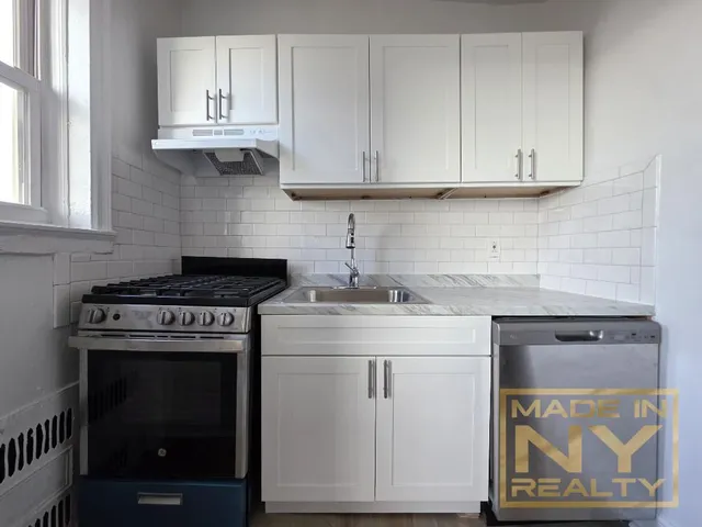 a kitchen with granite countertop white cabinets and a stove