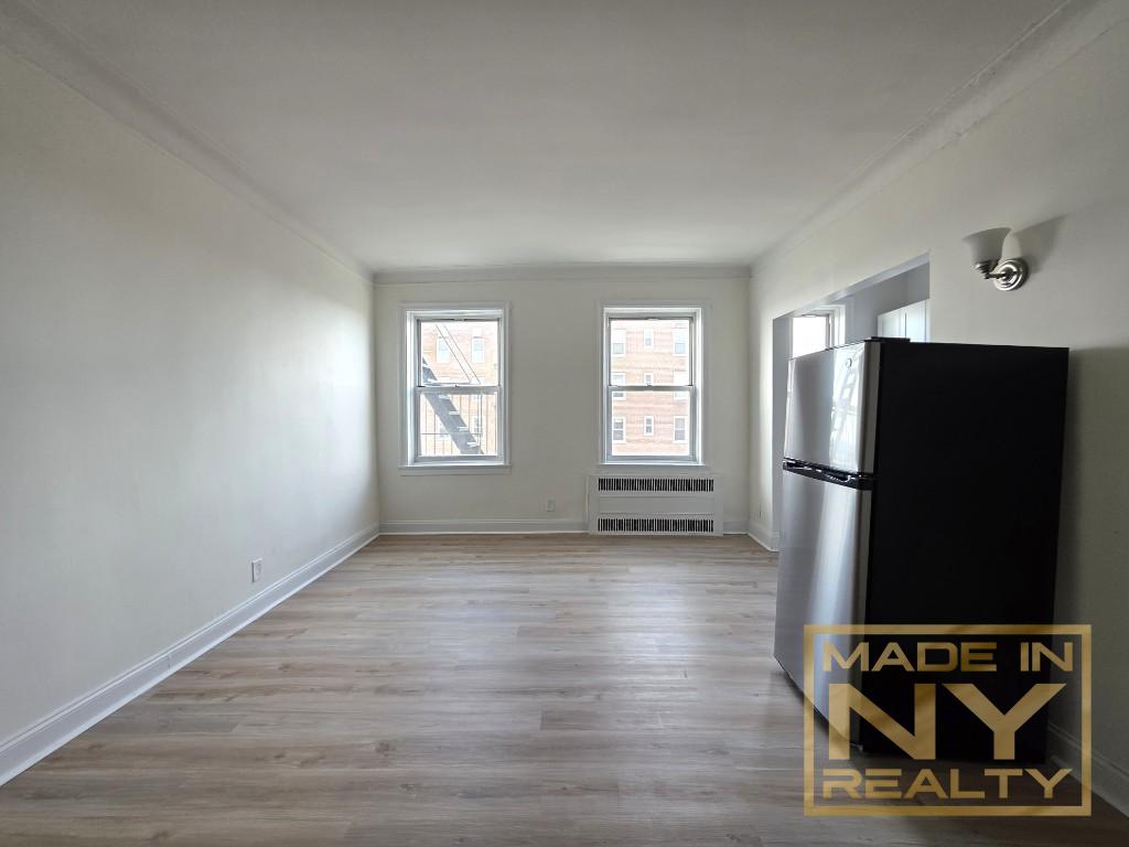 122-20 Ocean Prom, Unit 5B Queens, NY 11694 - Photo 2 of 4 an empty room with wooden floor cabinet and windows