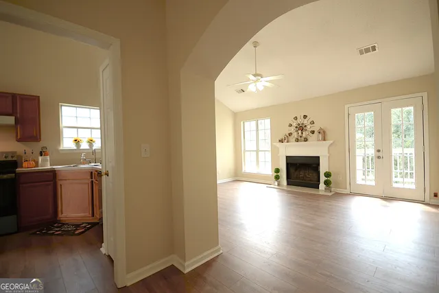 a view of an empty room with wooden floor and a window