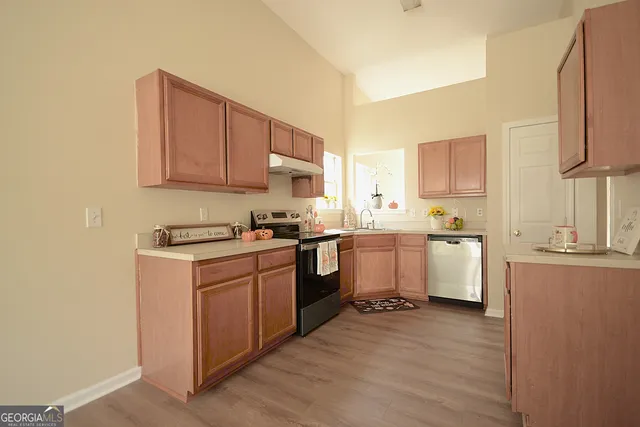 a kitchen with sink a stove and cabinets
