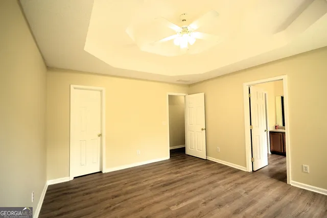 a view of empty room with wooden floor