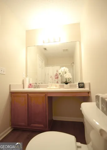 a bathroom with a granite countertop toilet sink and mirror