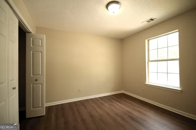 a view of an empty room with wooden floor
