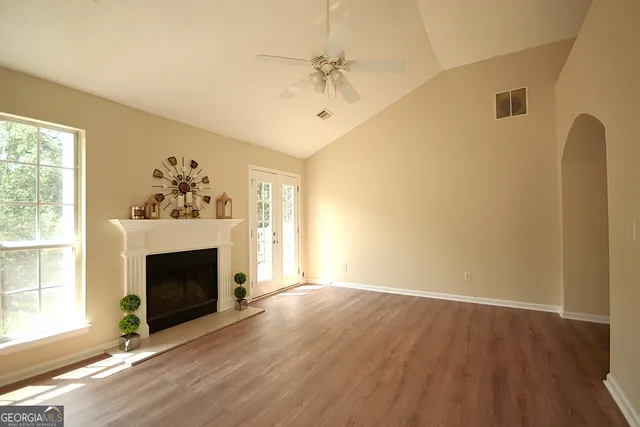 wooden floor fireplace and windows in an empty room