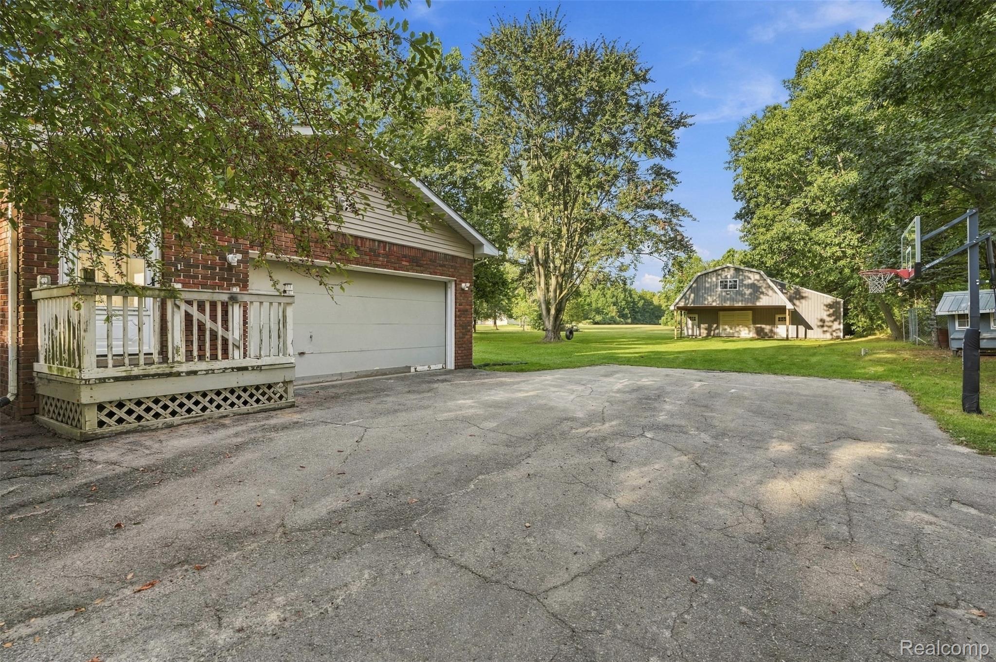 Brick exterior with siding accents, attached garage, and a raised wooden deck