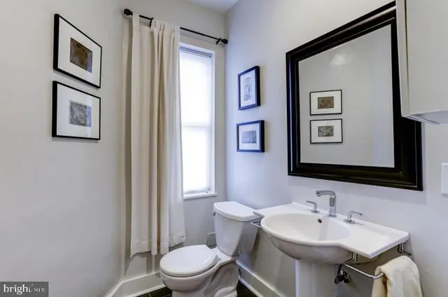 a bathroom with a toilet a sink and mirror