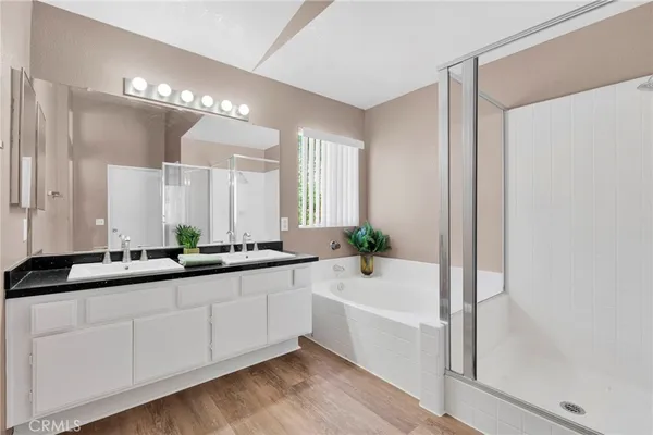 a bathroom with a tub a sink and mirror
