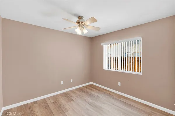 an empty room with windows and fan