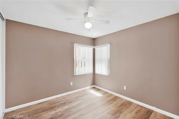 an empty room with a window and a fan
