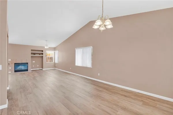 a view of a room with wooden floor and chandelier