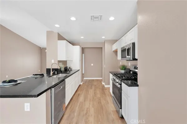 a large kitchen with stainless steel appliances granite countertop a stove and a sink