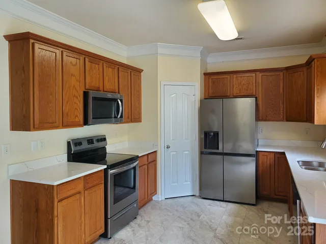 a kitchen with stainless steel appliances granite countertop a refrigerator and a microwave